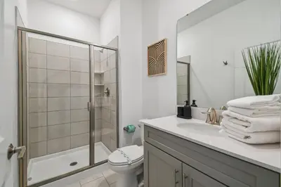a white bathroom with a toilet and a sink at Orlando Getaway – Minutes to Disney Parks in Kissimmee