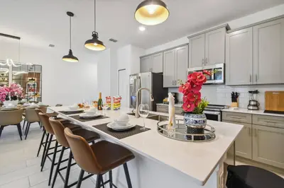 a large kitchen with a large island with chairs at Orlando Getaway – Minutes to Disney Parks in Kissimmee