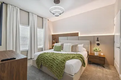 a bedroom with a large bed with a green blanket at Orlando Getaway – Minutes to Disney Parks in Kissimmee