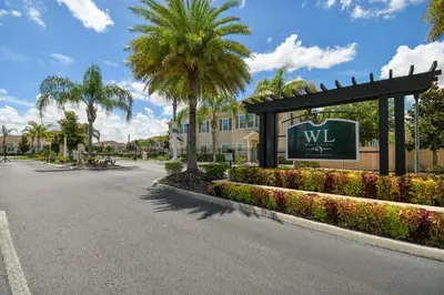 a sign for a villa with palm trees and a building at Family Getaway Near Disney Parks in Kissimmee