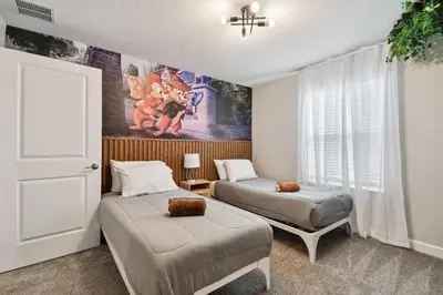 a bedroom with two beds and a painting on the wall at Disney Getaway: Private Pool Resort in Kissimmee