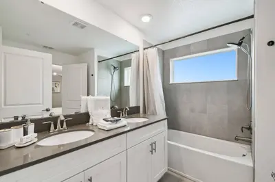 a white bathroom with two sinks and a shower at Private Pool Luxury Resort Amenities in Kissimmee