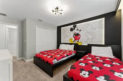 a bedroom with two beds and a mickey mouse poster at Luxury Family Stay Near Disney in Kissimmee