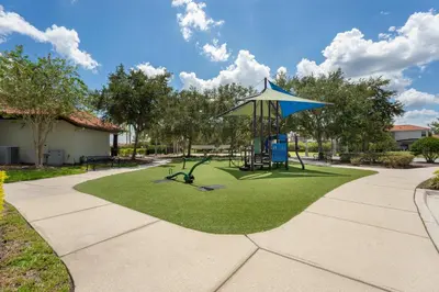 a playground with a umbrella and a swing at Family Townhome w Private Pool Orlando in Kissimmee