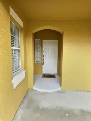 a yellow house with a white door and a window at Family Villa near Disney – 15 Min in Kissimmee