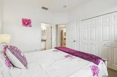 a bedroom with a white bed with purple pillows at 4BR Home Game Room in Lake Berkley in Kissimmee