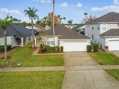 a house with white garage doors in a residential neighborhood at 4BR Home Game Room in Lake Berkley in Kissimmee