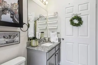 a bathroom with a sink and a toilet and a mirror at Resort Townhome · Sleeps 8 · Pool in Kissimmee