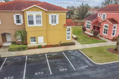 a house with a parking lot in front of it at Resort Townhome · Sleeps 8 · Pool in Kissimmee