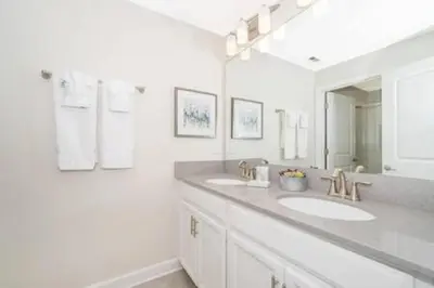 a white bathroom with two sinks and a mirror at Family Villa · Near Disney · Sleeps 10 in Kissimmee
