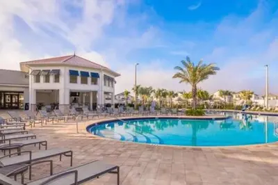 a swimming pool with chairs and a building at Family Villa · Near Disney · Sleeps 10 in Kissimmee
