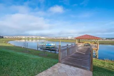 a dock with a gazebo next to a lake at Family Villa · Near Disney · Sleeps 10 in Kissimmee