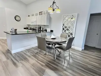 a kitchen and dining room with a table and chairs at Lake Berkley · Family Home Near Disney in Kissimmee