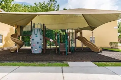 a playground with an umbrella and a slide at Lake Berkley · Family Home Near Disney in Kissimmee