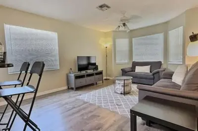 a living room with a couch and a tv at Montego Bay Retreat w Pool in Kissimmee