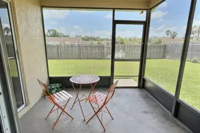 a patio with a table and two chairs on a porch at Montego Bay Retreat w Pool in Kissimmee