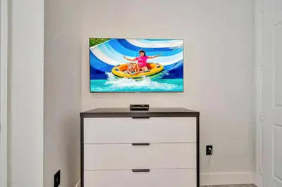 a painting of a woman on a surfboard in the water at Vista Cay Getaway · Orlando Stay in Orlando