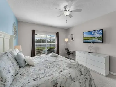 a bedroom with a large bed with a ceiling fan at Spacious Home · Near Disney Parks in Kissimmee