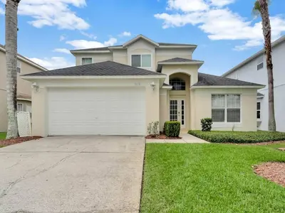 a large house with a white garage at Spacious Home · Near Disney Parks in Kissimmee