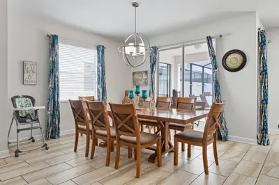 a dining room with a wooden table and chairs at Spacious 6BR Pool Resort - Near Disney in Kissimmee