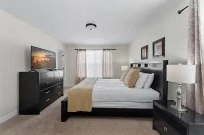 a bedroom with a bed and a dresser and a window at Spacious 6BR Pool Resort - Near Disney in Kissimmee
