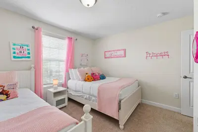 a childs bedroom with two beds and a window at Spacious 6BR Pool Resort - Near Disney in Kissimmee