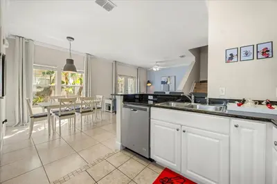 a kitchen with a sink and a table with chairs at Orlando Family Stay · Pool Clubhouse in Kissimmee