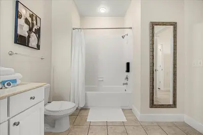 a white bathroom with a toilet and a shower at Orlando Family Stay · Pool Clubhouse in Kissimmee