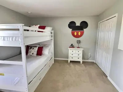 a room with two bunk beds with a mickey mouse on the wall at Family Getaway wPvt Pool close to Disney in Kissimmee