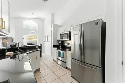 a kitchen with a stainless steel refrigerator and appliances at Two Master Suites Private Pool in Kissimmee