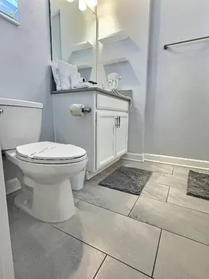 a white bathroom with a toilet and a shower at Family Getaway near Disney Sleeps 13 in Kissimmee