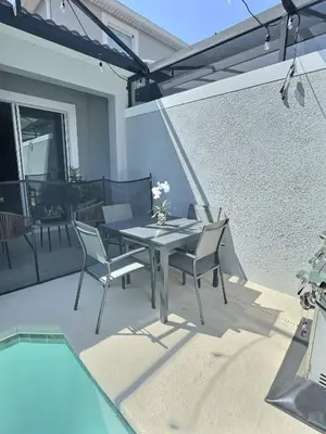 a patio with a table and chairs next to a pool at Family Getaway near Disney Sleeps 13 in Kissimmee