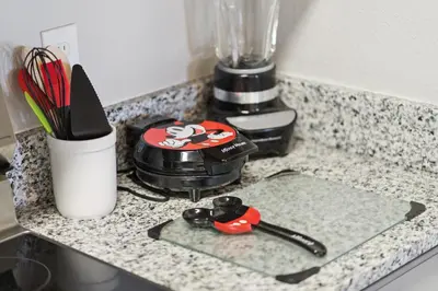 a counter top with a blender and some utensils at 3BR Windsor Hills Condo Water Park and Skeeball Near Disney No Resort Fees in Orlando