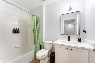 a bathroom with a toilet and a sink and a mirror at Family Townhouse 10 Min to Parks with Themed Room in Kissimmee