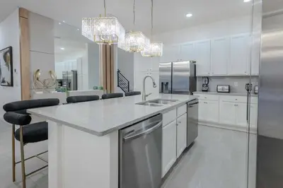 a white kitchen with a sink and a counter at Brand New12 Bedrooms Single Family Paradiso 09HI in Orlando