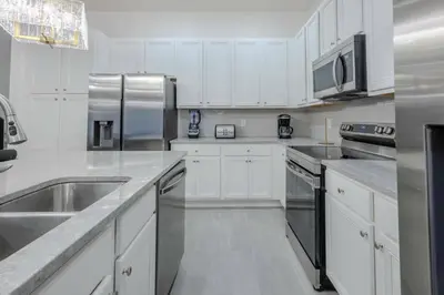 a kitchen with white cabinets and stainless steel appliances at Brand New12 Bedrooms Single Family Paradiso 09HI in Orlando