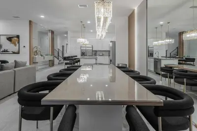 a dining room with a long table and black chairs at Brand New12 Bedrooms Single Family Paradiso 09HI in Orlando