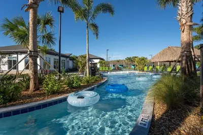 a pool at a resort with palm trees at Townhouse 4Q em Storey Lake – 10 min da Disney in Kissimmee