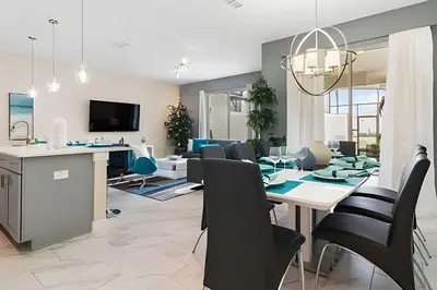 a dining room and living room with a table and chairs at Townhouse 4Q em Storey Lake – 10 min da Disney in Kissimmee