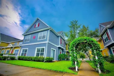 a blue house with an arch in a yard at 4 Bedroom 3 Bathroom Villas At SevenDwarfs 16-101 in Kissimmee