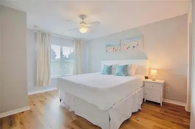 a bedroom with a white bed with a ceiling fan at 4 Bedroom 3 Bathroom Villas At SevenDwarfs 16-101 in Kissimmee