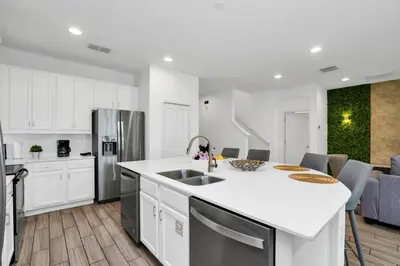 a kitchen with white cabinets and a white counter top at Spacious Disney-Area Home with Private Pool in Kissimmee