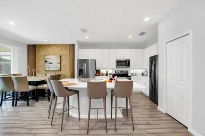 a kitchen with a large white table and chairs at Spacious Disney-Area Home with Private Pool in Kissimmee