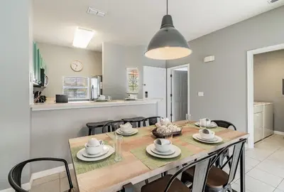 a kitchen and dining room with a table and chairs at Casa Moderna 3Q c/ Piscina Aquecida – 10min Disney in Kissimmee