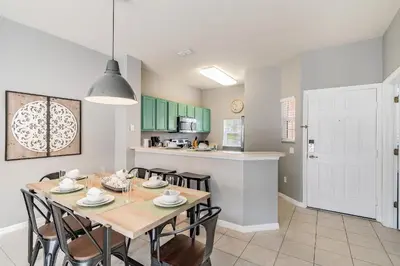 a kitchen and dining room with a table and chairs at Casa Moderna 3Q c/ Piscina Aquecida – 10min Disney in Kissimmee