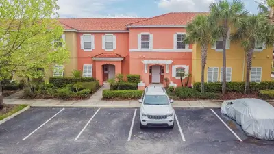 a car parked in a parking lot in front of a house at Casa Moderna 3Q c/ Piscina Aquecida – 10min Disney in Kissimmee