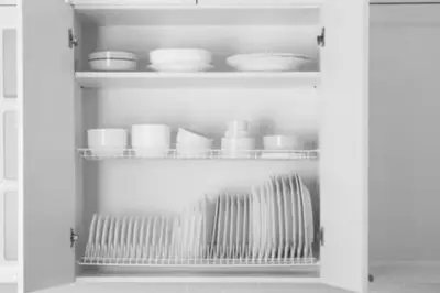 a white cabinet filled with bowls and plates at 2 Bedroom Deluxe - Theme Park in Orlando