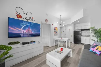 a living room with a large tv on the wall at 2 Queen Beds Theme Park in Orlando