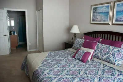 a bedroom with a large bed with purple pillows at Venetian Bay Townhome townhouse in Kissimmee