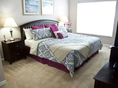 a bedroom with a bed with purple and pink pillows at Venetian Bay Townhome townhouse in Kissimmee